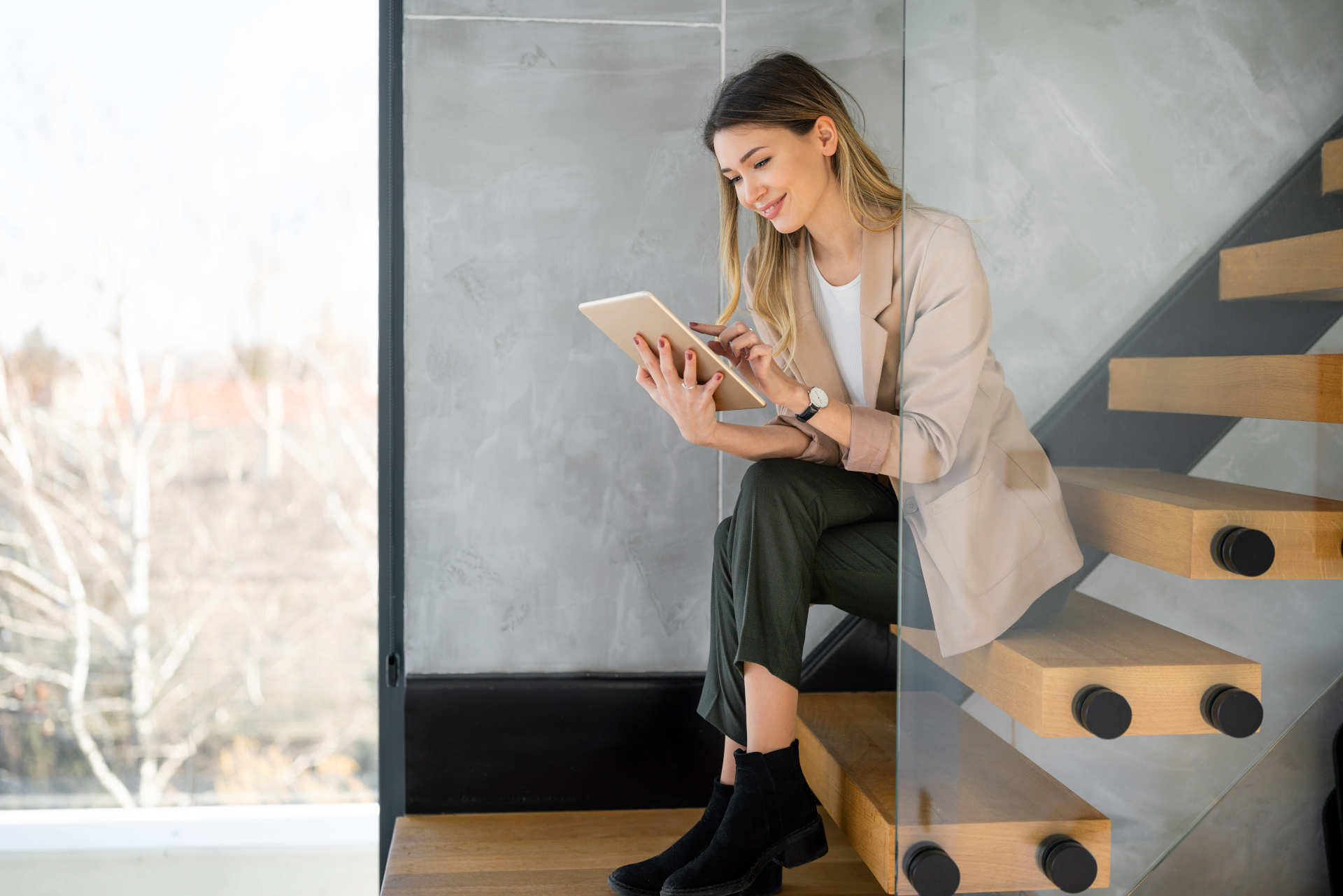 Frau mit Tablet auf der Treppe