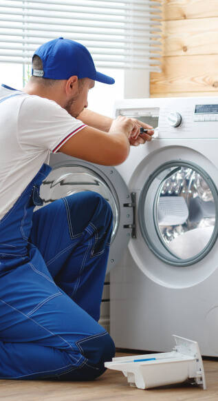 Een vakman repareert een wasmachine